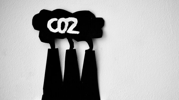 schakelaars met daarboven pictogram van Co2 uitstoot uit schoorstenen