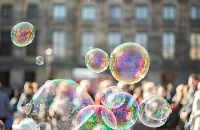 Groep mensen met op de voorgrond zeepbellen in de zon
