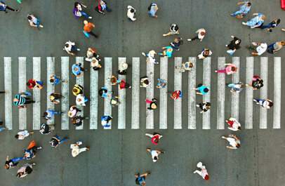 Veel mensen op een zebrapad, gezien van bovenaf