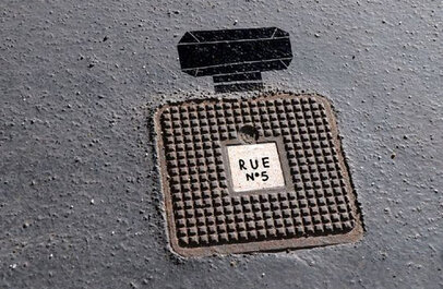 Van een putdeksel is dmv een schildering een flesje Chanel no. 5 gemaakt