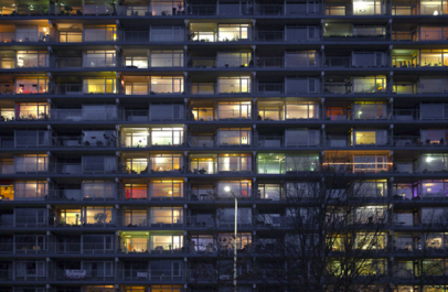 Appartementencomplex: veel grote ramen, achter sommige brandt licht