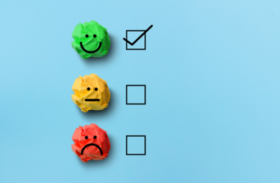 Blije, neutrale en verdrietige smiley onder elkaar; achter de blije staat een vinkje