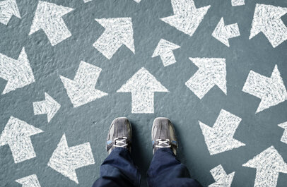 Voeten op de grond, daar omheen vele pijlen in verschillende richtingen.