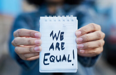 Iemand houdt papier omhoog met de tekst 'we are equal'