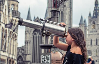 Meisje kijkt door verrekijker in centrum van Gent