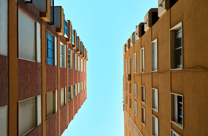 Twee hoge flatgebouwen van onderaf gefotografeerd