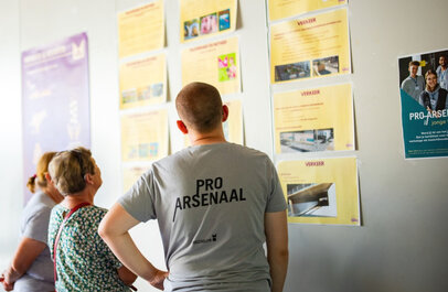 Verschillende aspecten van het project PRO Arsenaal worden met posters aan de muur getoond aan verschillende geïnteresseerden