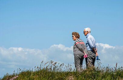 Ouder echtpaar buiten aan het wandelen, kijken uit vanaf een hoger gelegen stuk