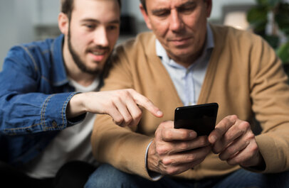 Zoon wijst iets aan op de GSM van vader