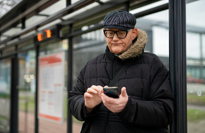 Man kijkt vertwijfeld naar zijn smartphone