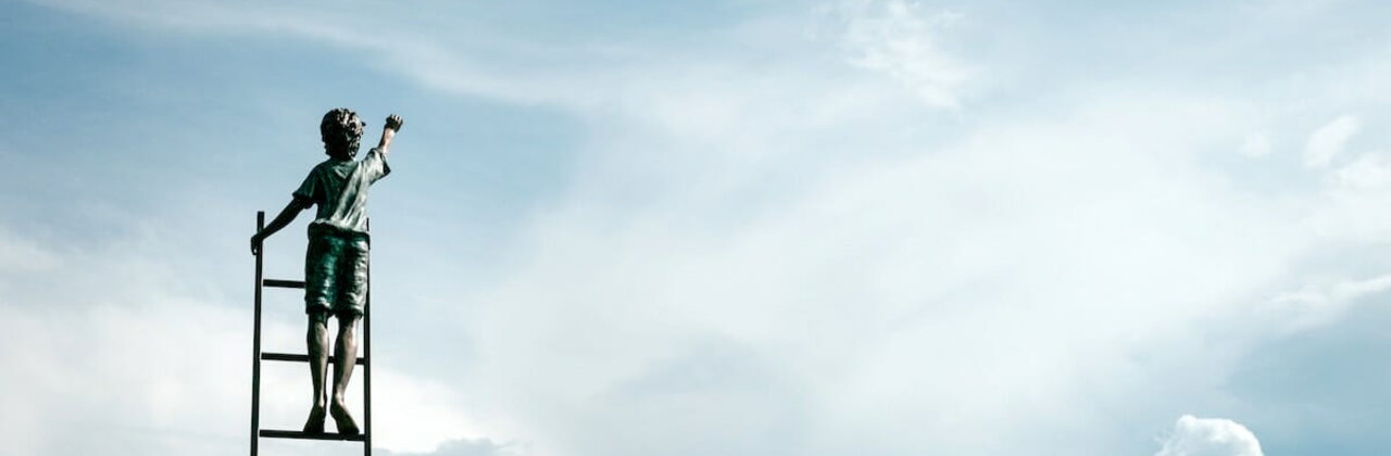 Jongetje op een ladder in de lucht, wijst omhoog