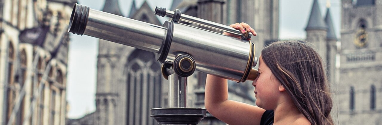 Meisje kijkt door verrekijker in centrum van Gent