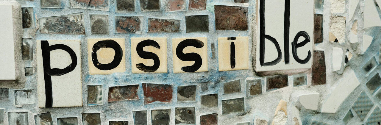 Mozaïek met tegeltjes en de letters van het woord 'possible'