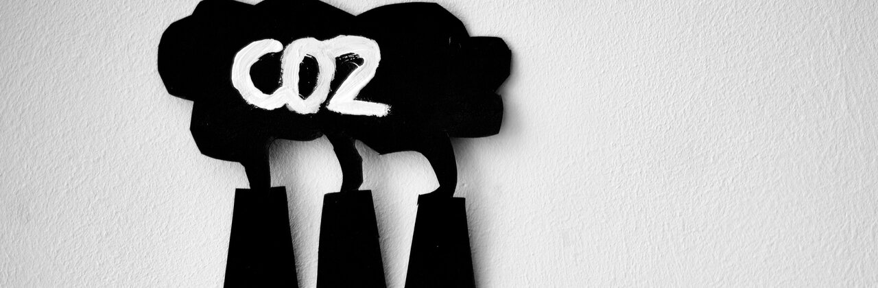 schakelaars met daarboven pictogram van Co2 uitstoot uit schoorstenen