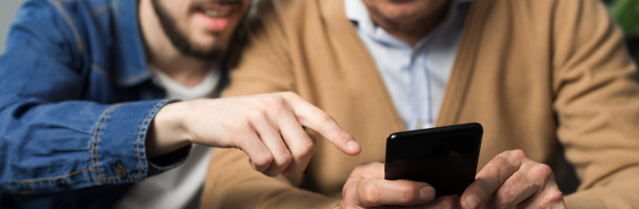 Zoon wijst iets aan op de GSM van vader