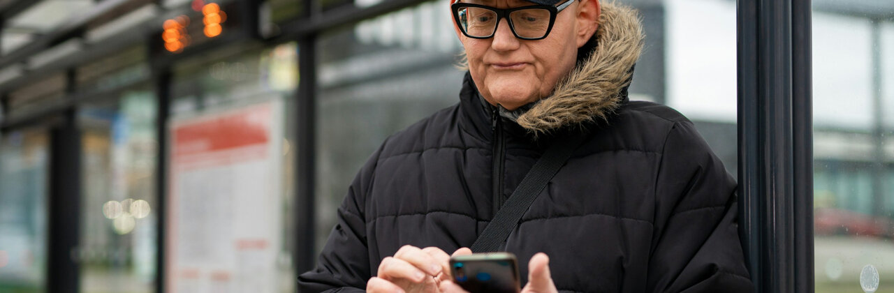 Man kijkt vertwijfeld naar zijn smartphone