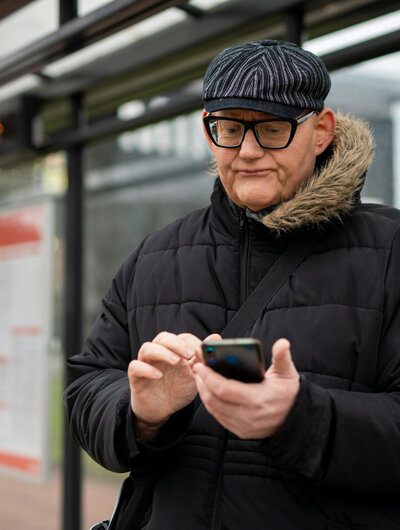 Man kijkt vertwijfeld naar zijn smartphone